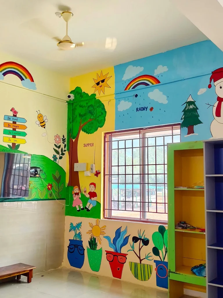 Full-wall classroom painting with trees, a rainbow and flower pots around the windows — Sri Krishnasamy International School, Sivakasi