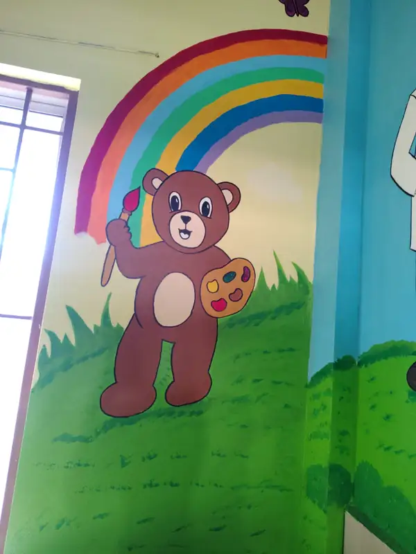 Teddy bear with paintbrush under a rainbow — Essence flat-colour wall painting by Bhuvi