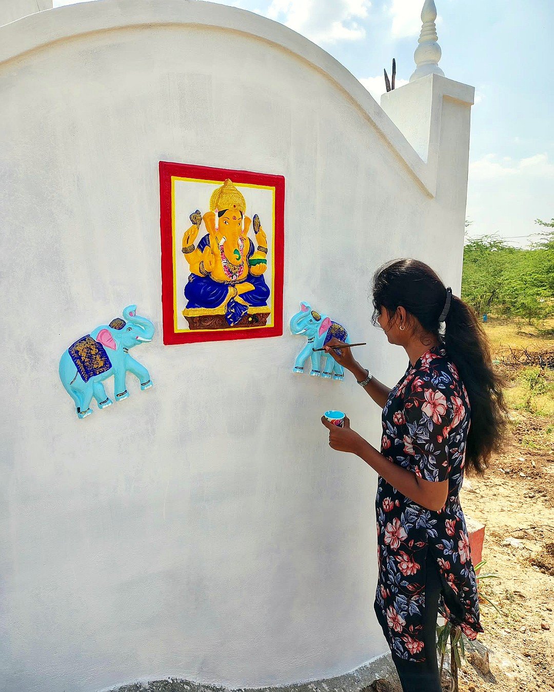 Bhuvi hand-painting a Vinayagar wall mural